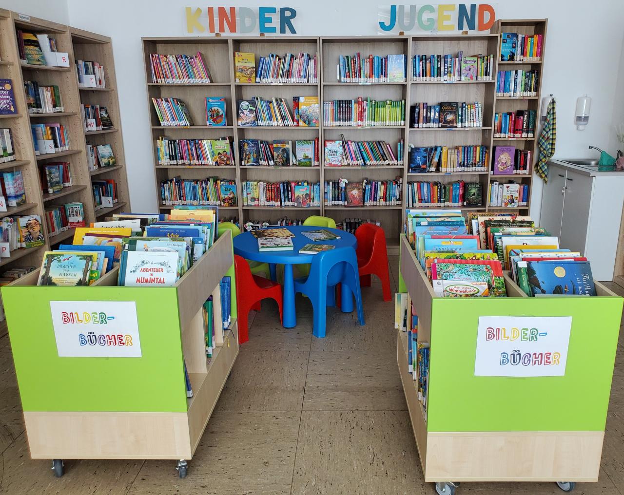 Bücher imRegal und in zwei Buchwägen