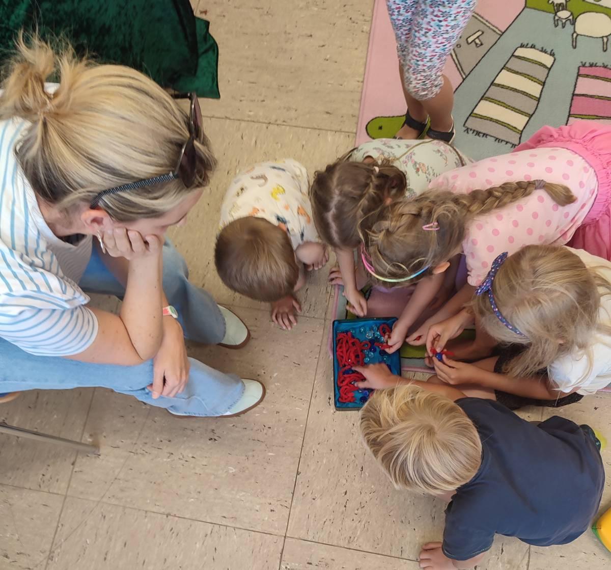 Kinder am Boden vor Schatzdose