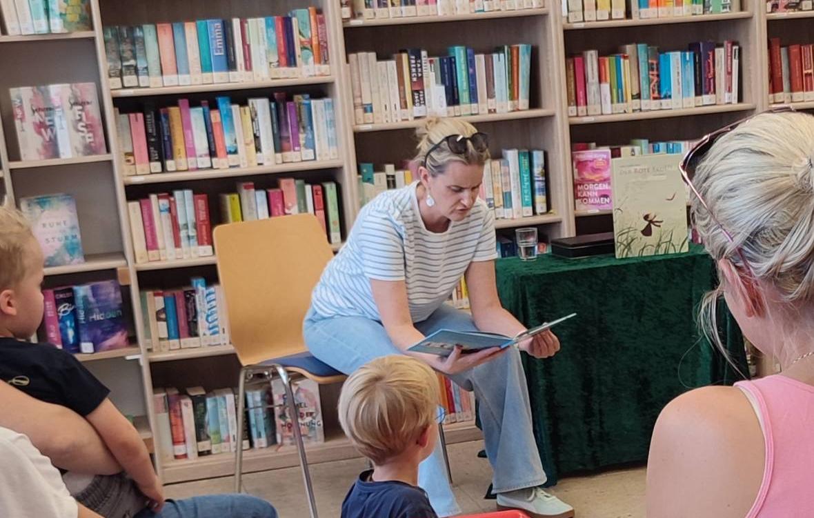 Kinder und Erwachsene hören einer Lesung zu