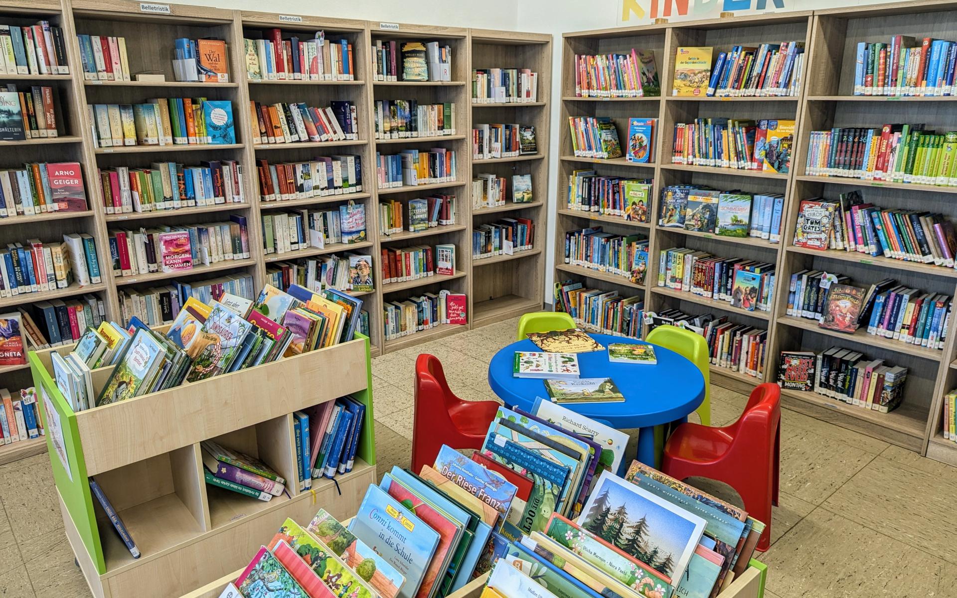 Buchregal, kleine bunte Stühle mit Tisch für Kinder