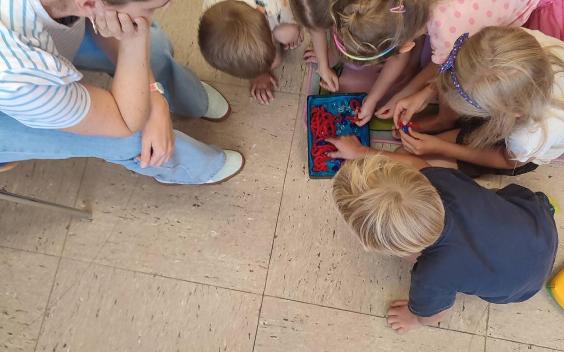 Kinder am Boden vor Schatzdose