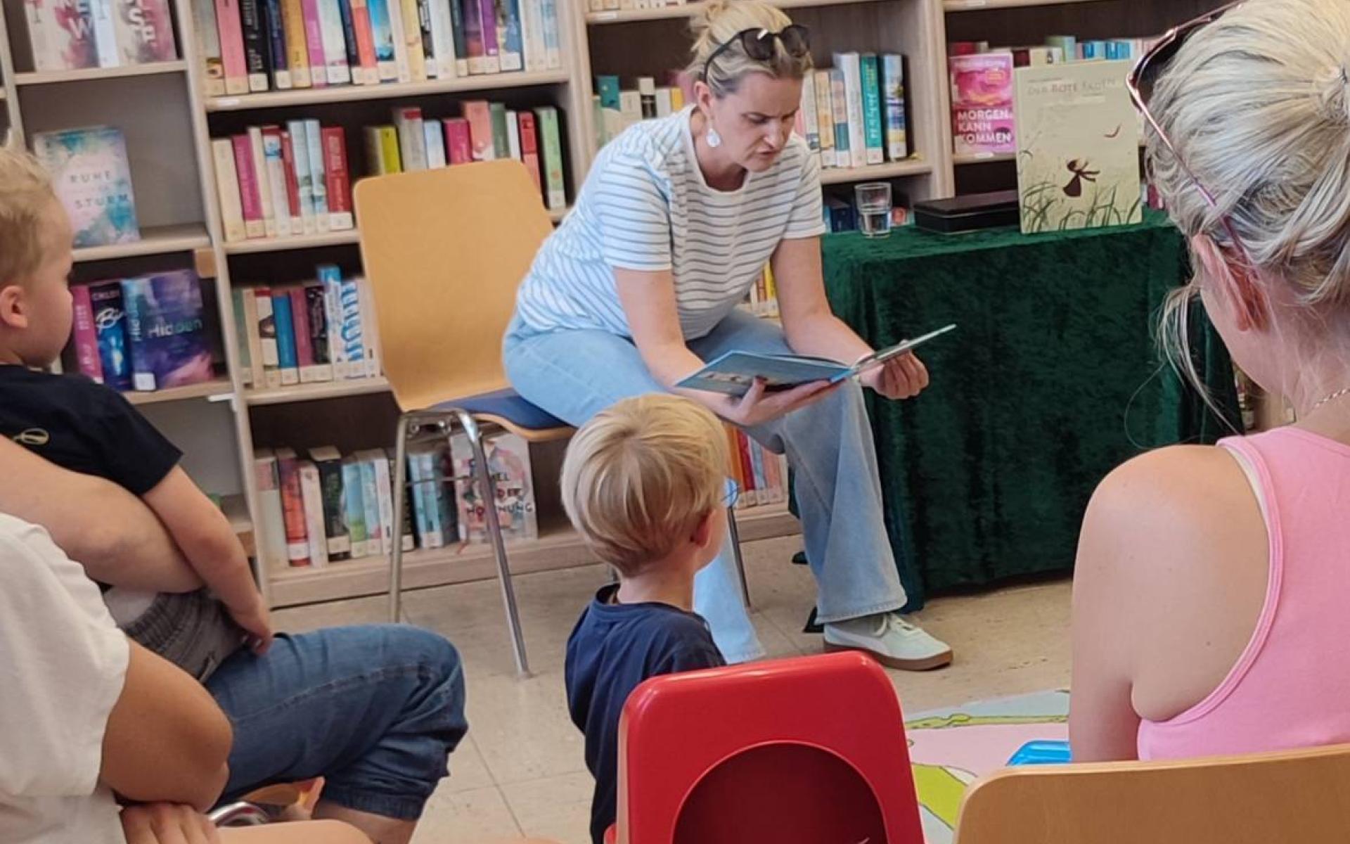 Kinder und Erwachsene hören einer Lesung zu