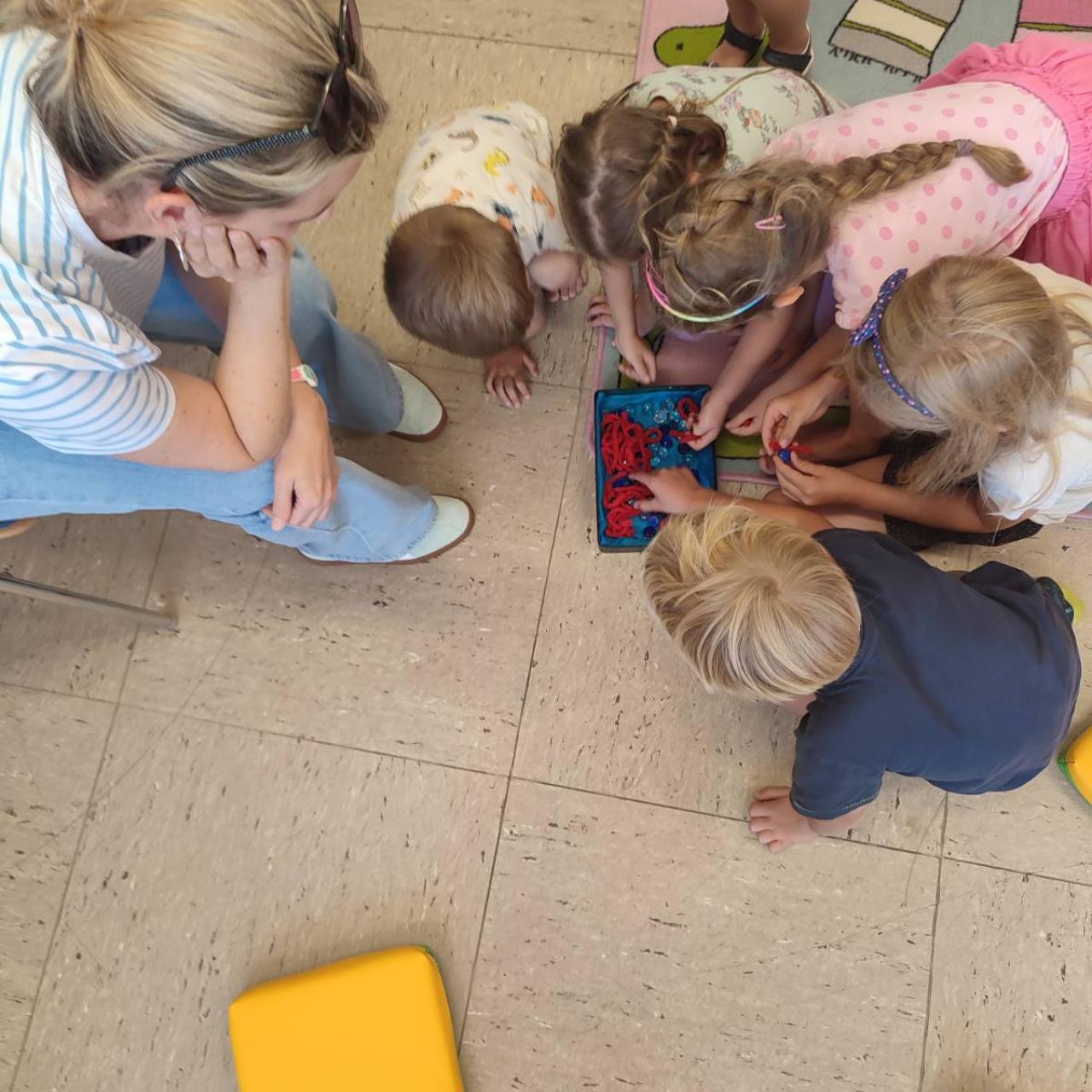 Kinder am Boden vor Schatzdose